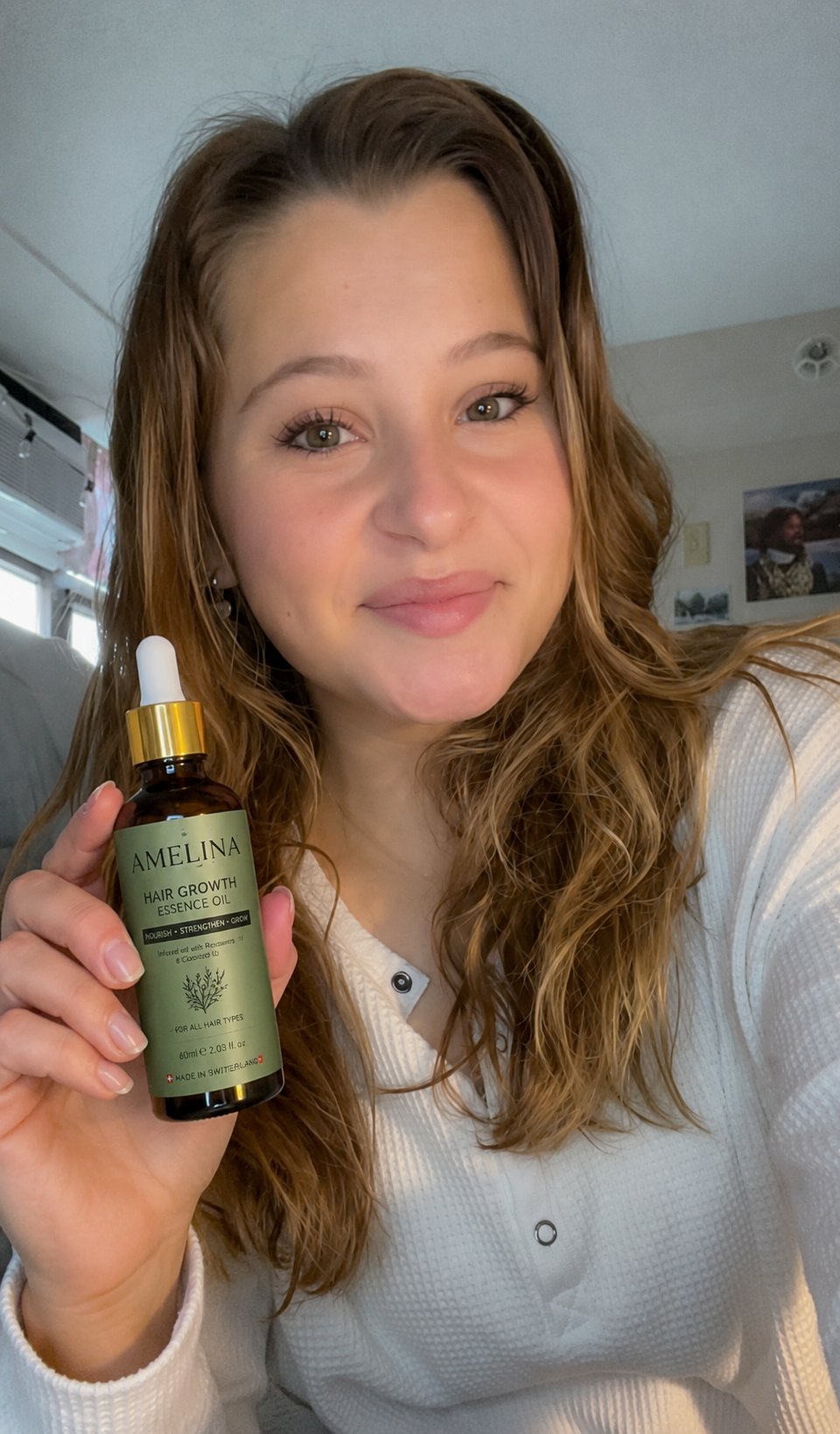 Happy AMELINA customer holding the Hair Growth Essence Oil bottle